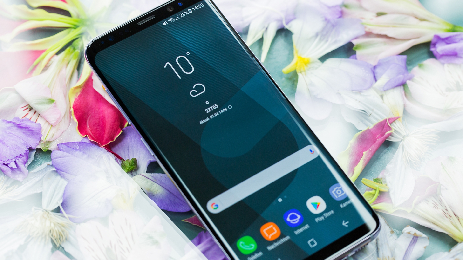 Samsung Galaxy S8 Das Galaxy S8 liegt auf einer Blümchendecke.