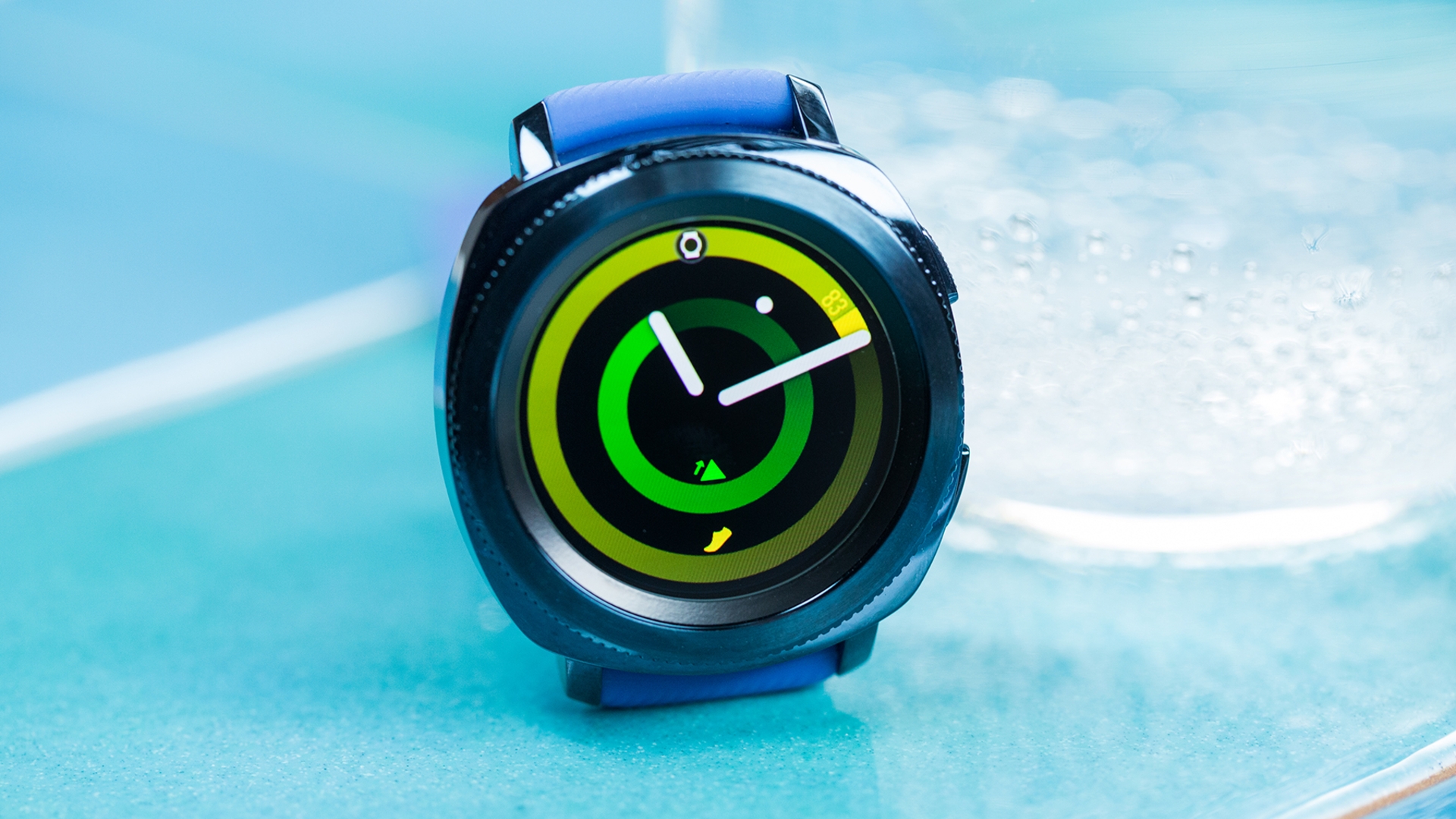 Samsung Gear Sport Die Gear Sport mit gelbgrünem Zifferblatt vor blauem Hintergrund.