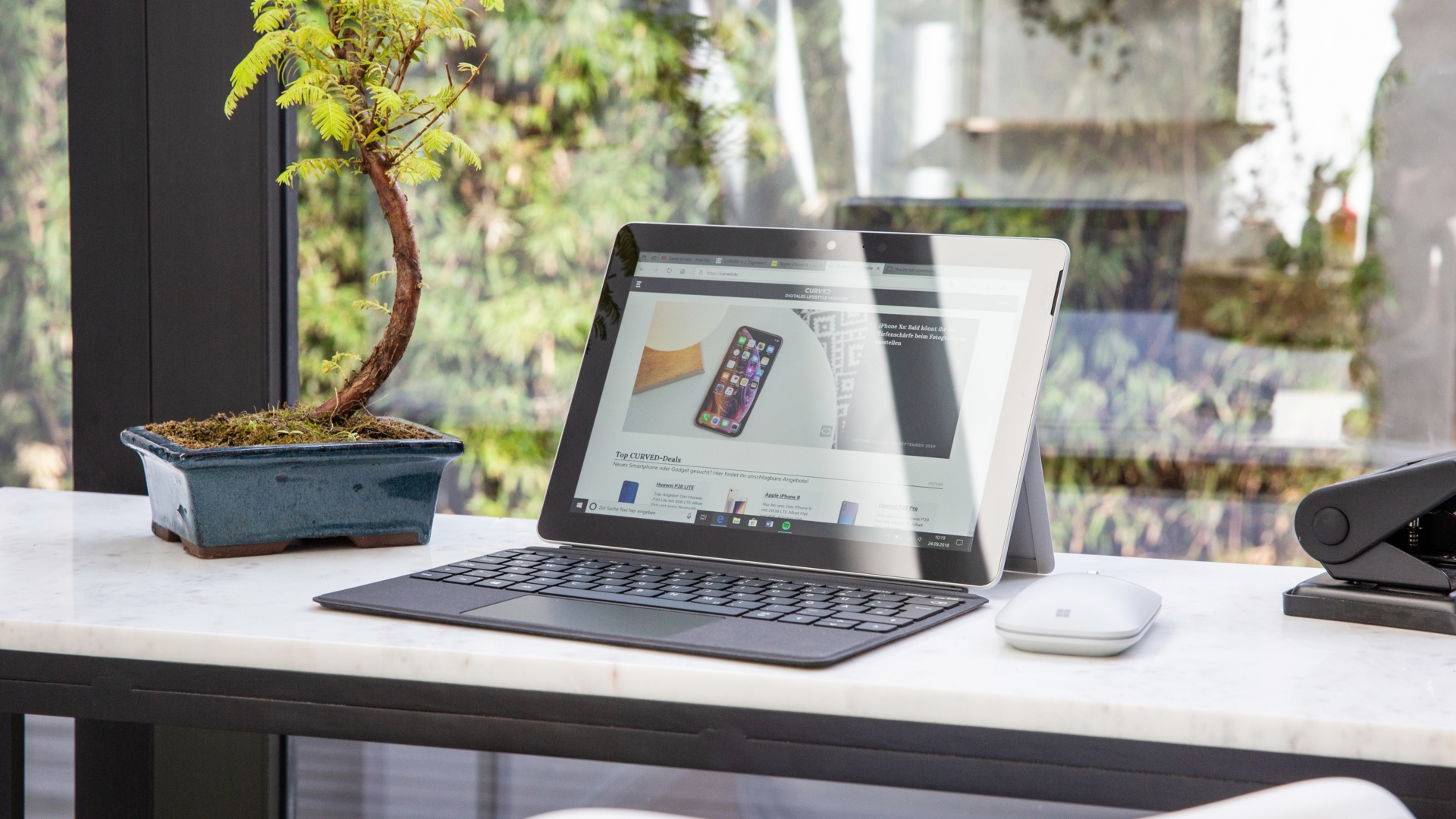Microsoft Surface Go Notebook mit Maus auf einem Tisch