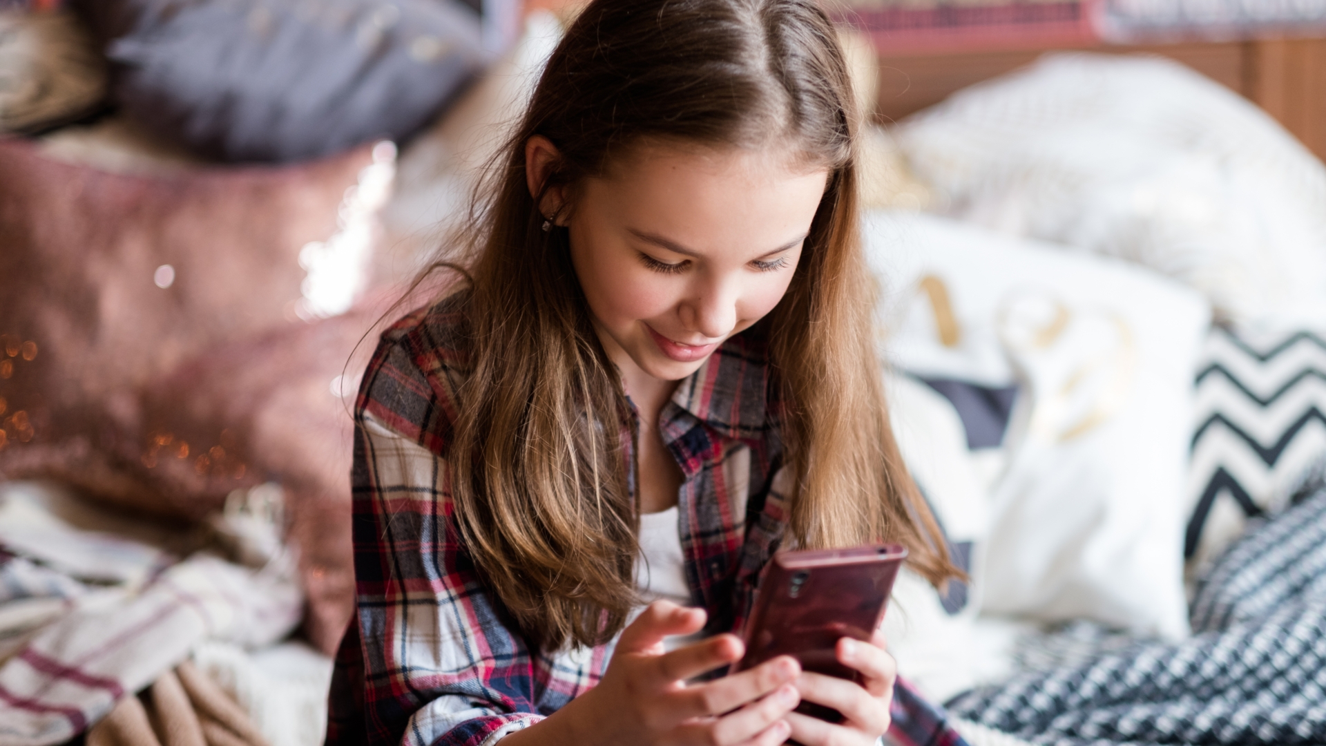 Kind schaut auf Smartphone in seinen Händen