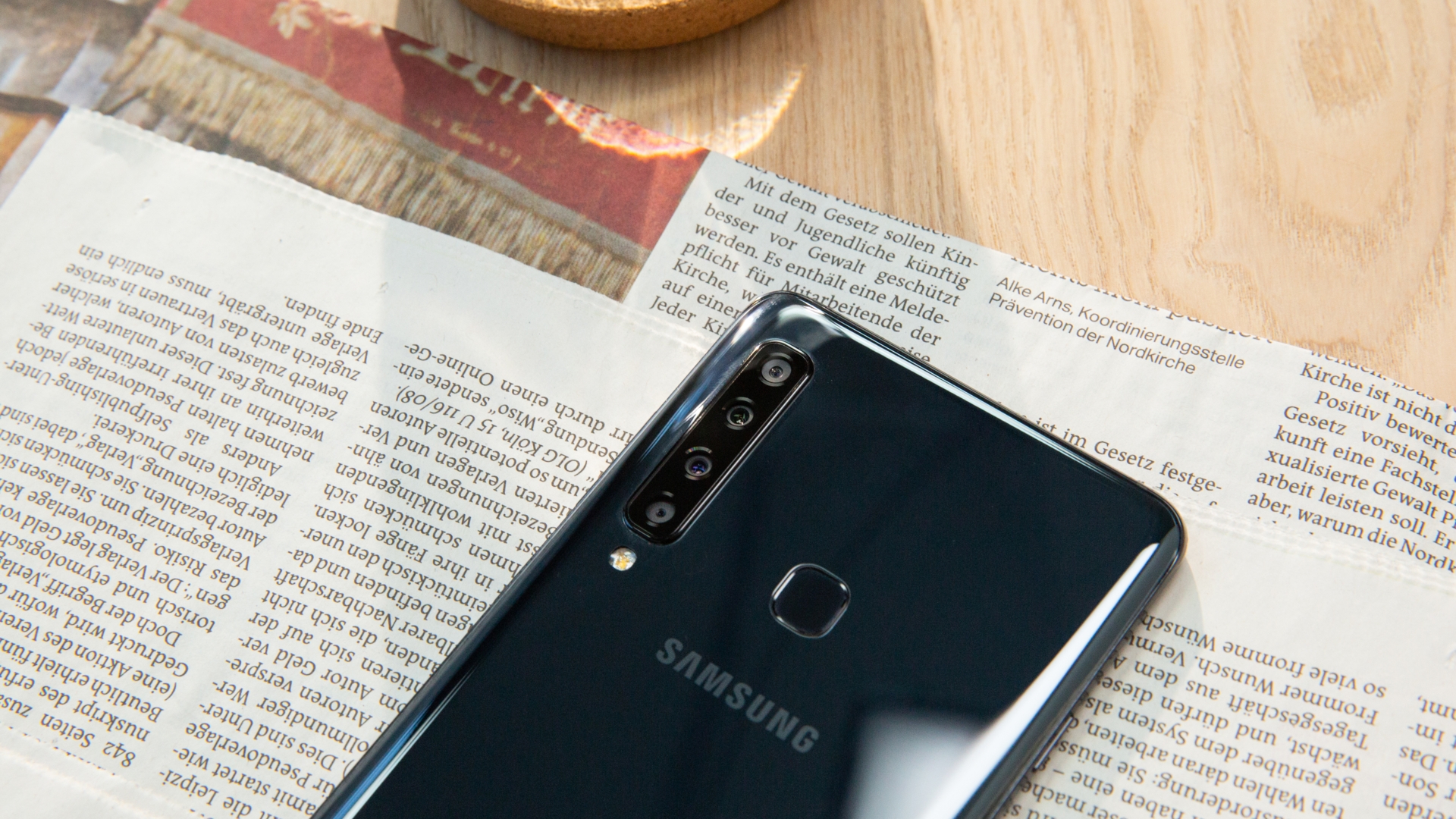 Samsung Galaxy A9 Das Samsung Galaxy A9 (2018) liegt auf dem Tisch auf einer Zeitung.