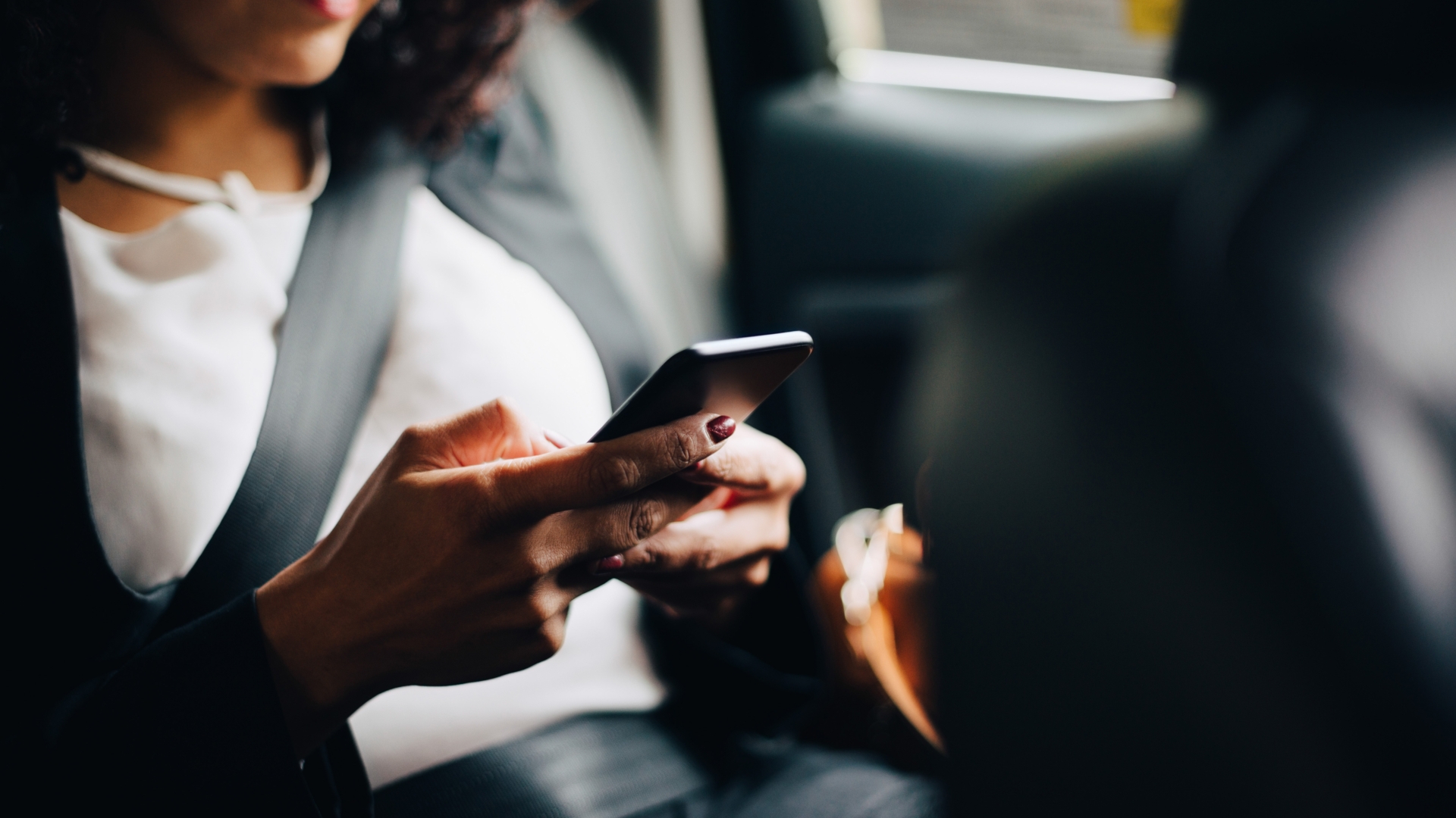 Frau im Auto mit Smartphone