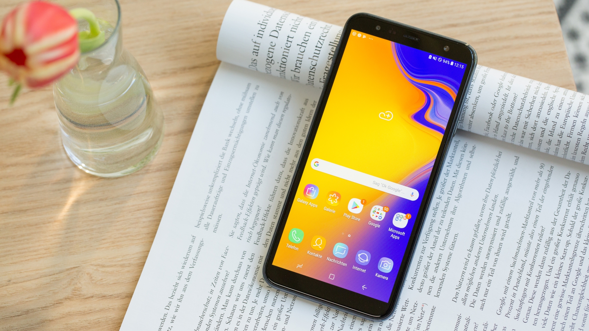 Samsung Galaxy J4 Plus (2018) Ein Samrtphone liegt auf einer aufgeschlagenen Zeitschrift.