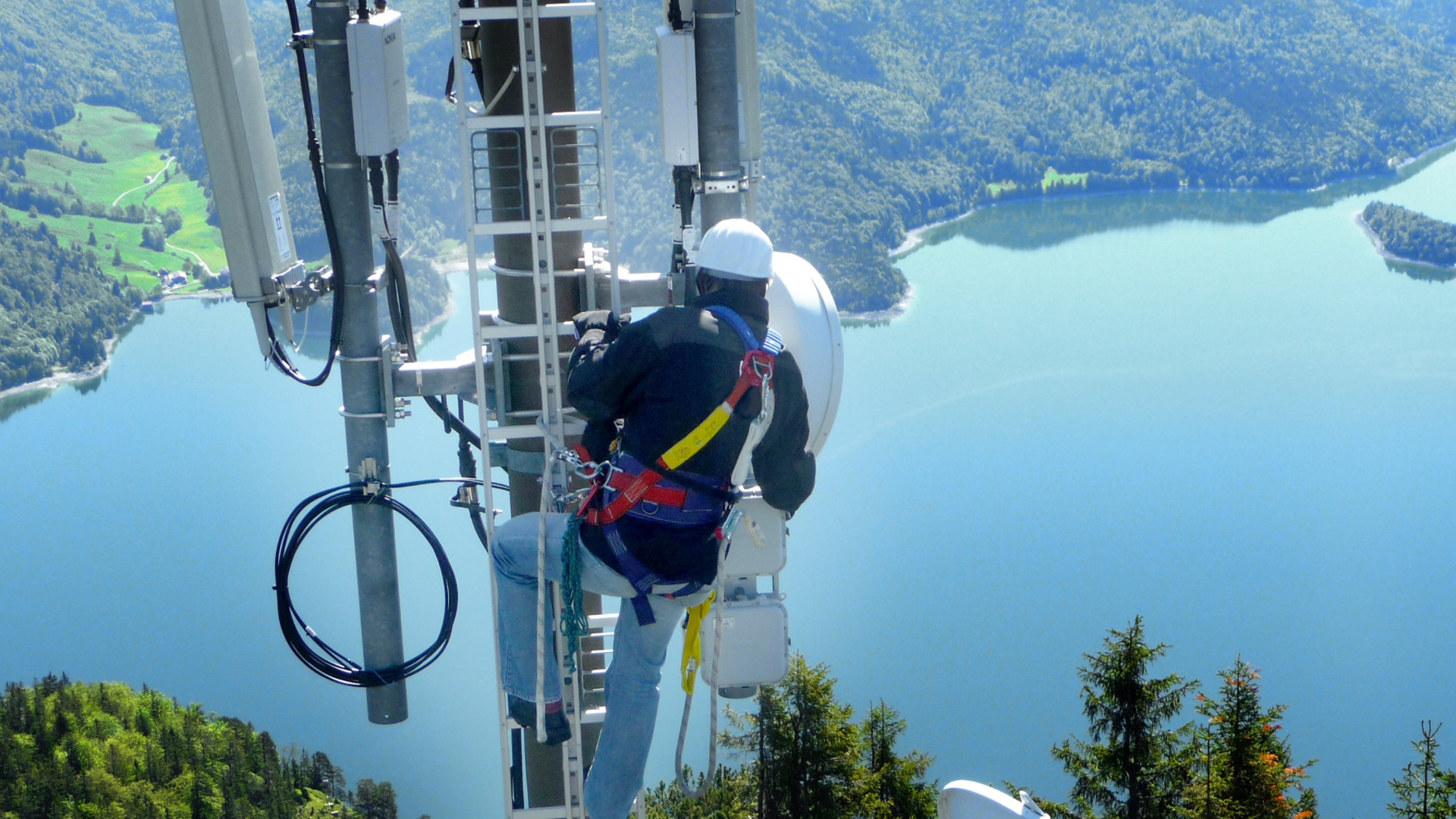 Telefonica Netzausbau Deutschland Flickr Techniker arbeitet in großer Höhe an Funkmasten vor Bergsee-Panorama