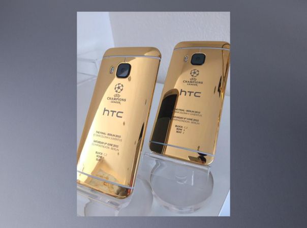 Rechts unten spiegelt sich ein iPhone 6 im Goldgehäuse des HTC One M9