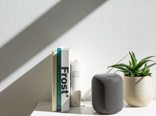 Apple HomePod Der HomePod zwischen Büchern und einer Pflanze
