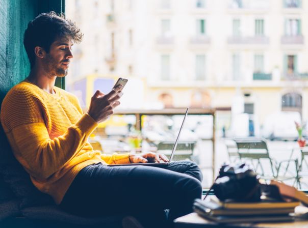 Junger Mann mit Smartphone im Café