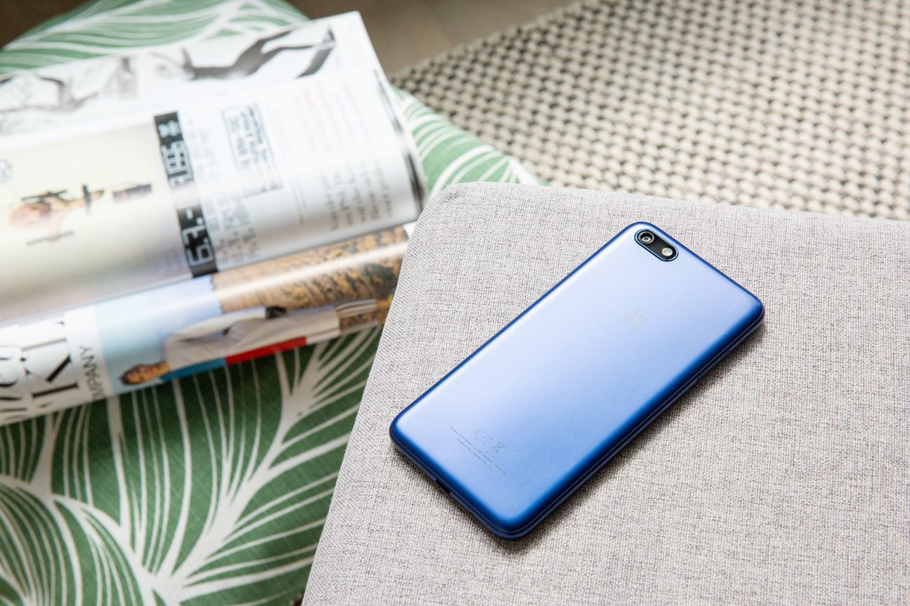 Huawei Y5 Das Huawei Y5 (2018) auf einem grauen Polster.