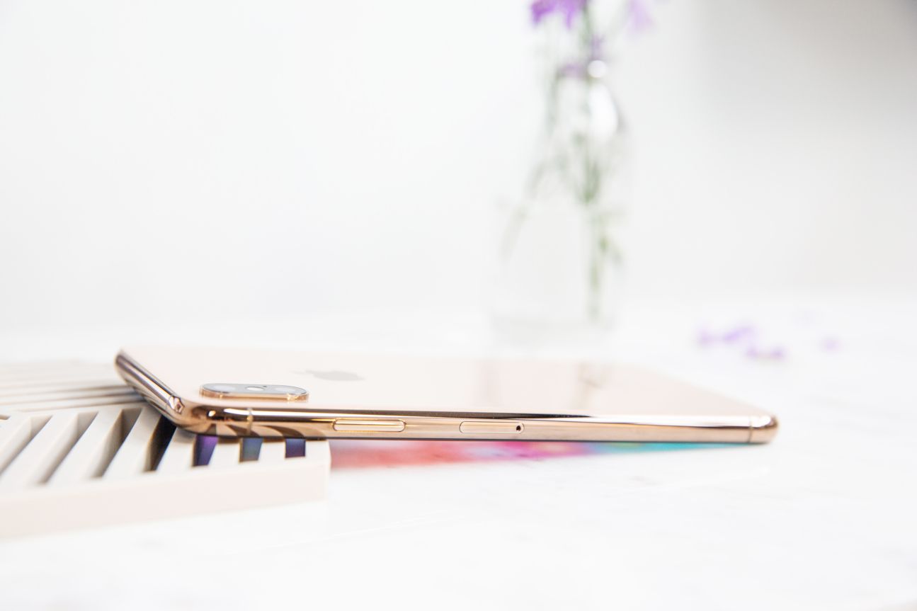 Apple iPhone Xs Max Das iPhone Xs Max von der Seite auf einem weißen Tisch.