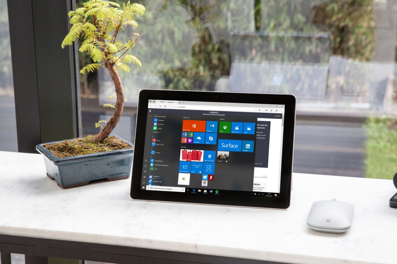 Microsoft Surface Go Notebook und Maus auf einem Tisch.