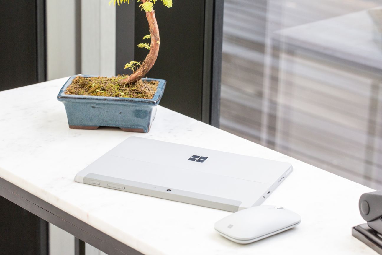 Microsoft Surface Go Tablet und Maus auf einem Tisch.
