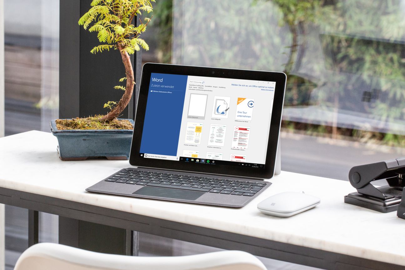 Microsoft Surface Go Notebook und Maus auf einem Tisch.