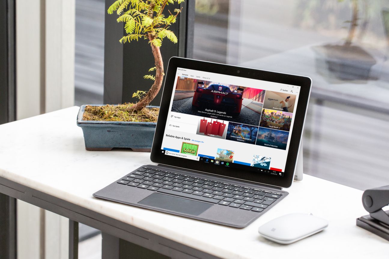 Microsoft Surface Go Notebook und Maus auf einem Tisch.