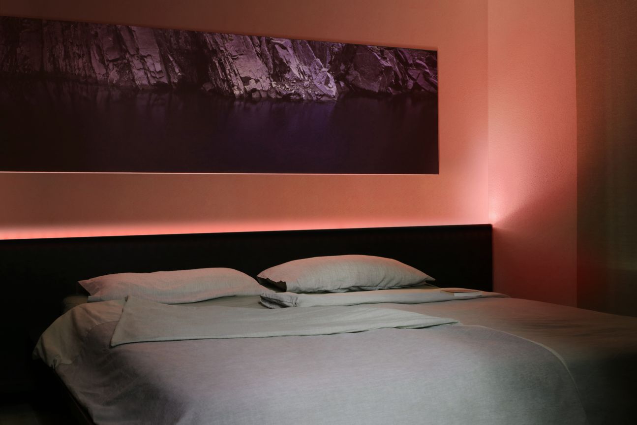 Eve Light Strip Eve Light Strip leuchtet hinter dem Bett in Koralle