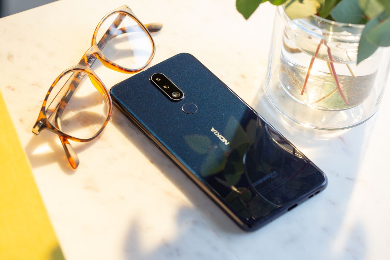 Nokia 5.1 Plus Das Nokia 5.1 Plus liegt auf einem Tisch neben einer Brille.