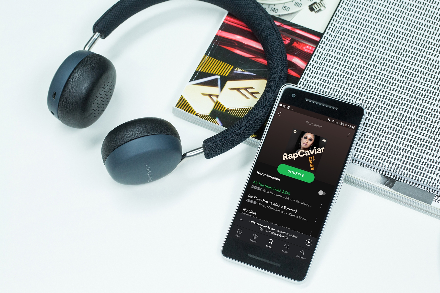 Smartphone mit Spotify App und Kopfhörer auf Tisch