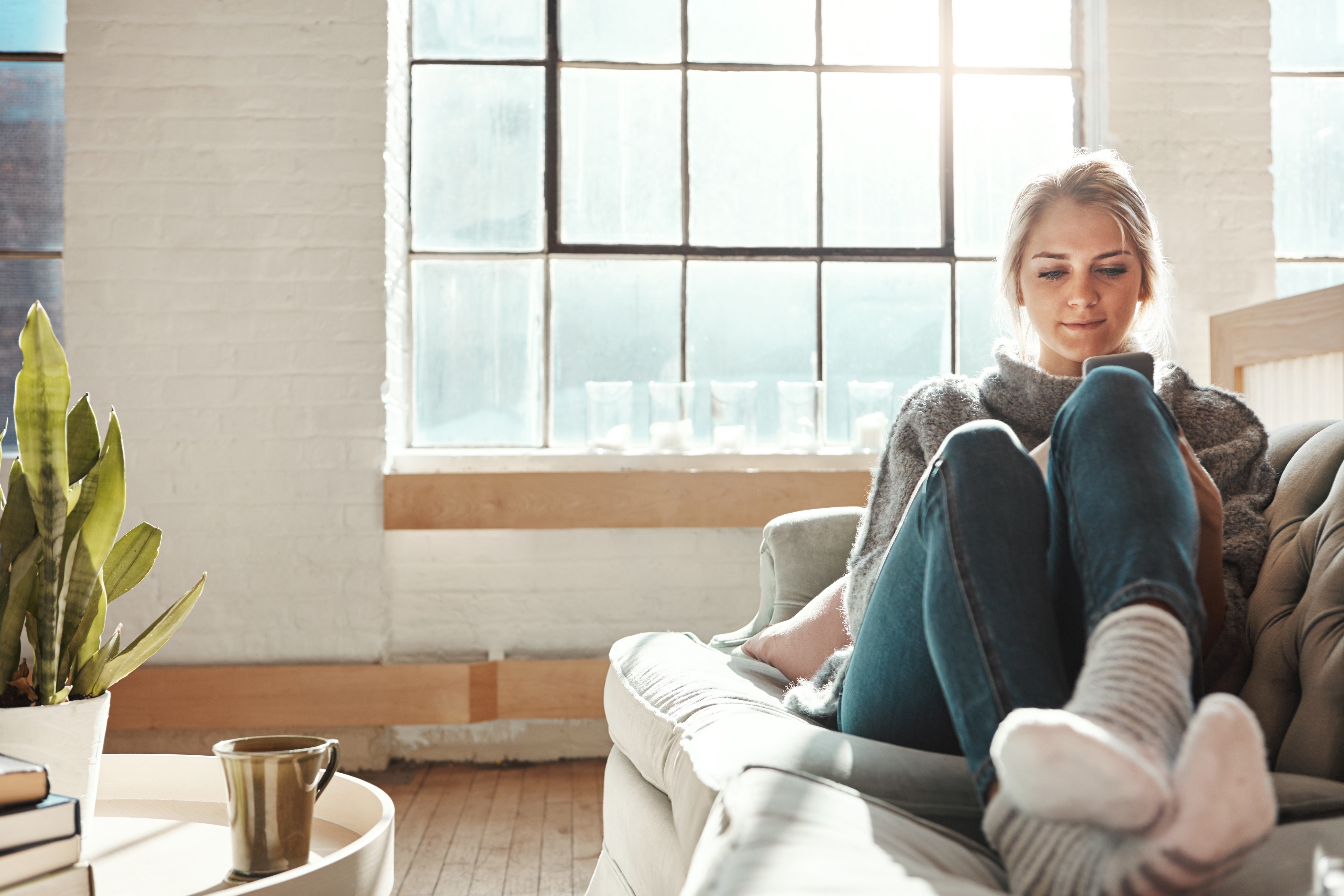 Frau mit Handy auf der Couch