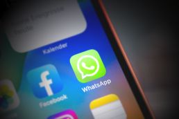 Neue Statusmeldungen werden in WhatsApp mit farbigen Kreisen angezeigt WhatsApp-Symbol auf iPhone 14 Display